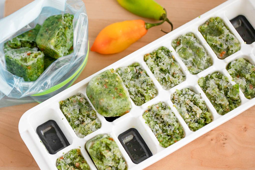 Frozen Carribbean green seasoning in an ice tray removed and placed in a plastic baggie 