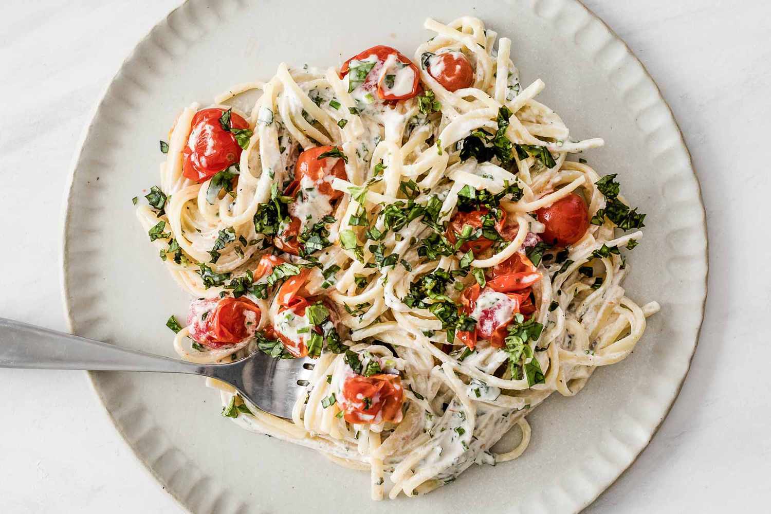 Vegan pasta with herb sauce and tomatoes