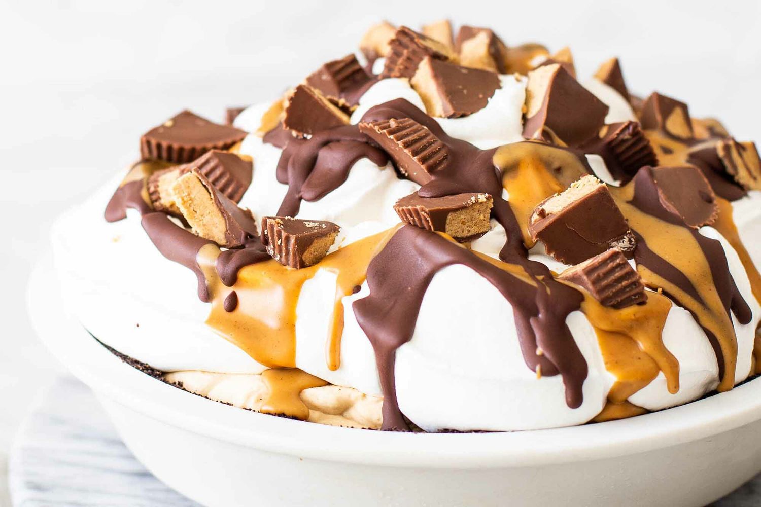 Chocolate penaut butter pie topped with whipped cream and peanut butter cups.