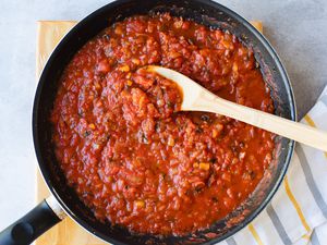 Homemade Tomato Sauce in a skillet with a wooden spoon