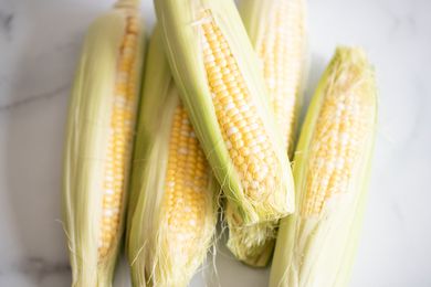 pile of corn with husk still on