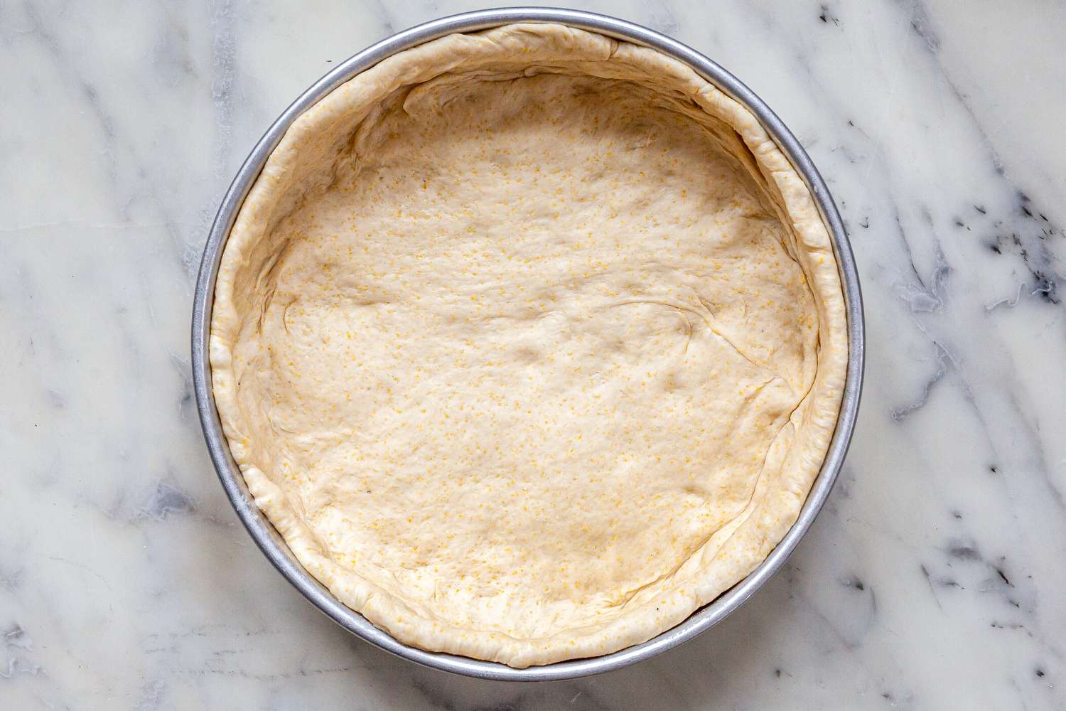 Chicago-Style Deep Dish Pizza dough shaped in a pan.