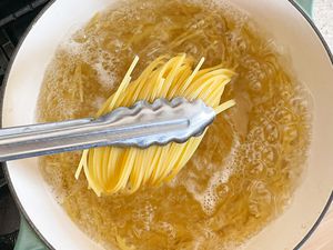 Tongs Lifting Spaghetti from Pot of Boiling Water for No Cook Tomato Sauce Pasta
