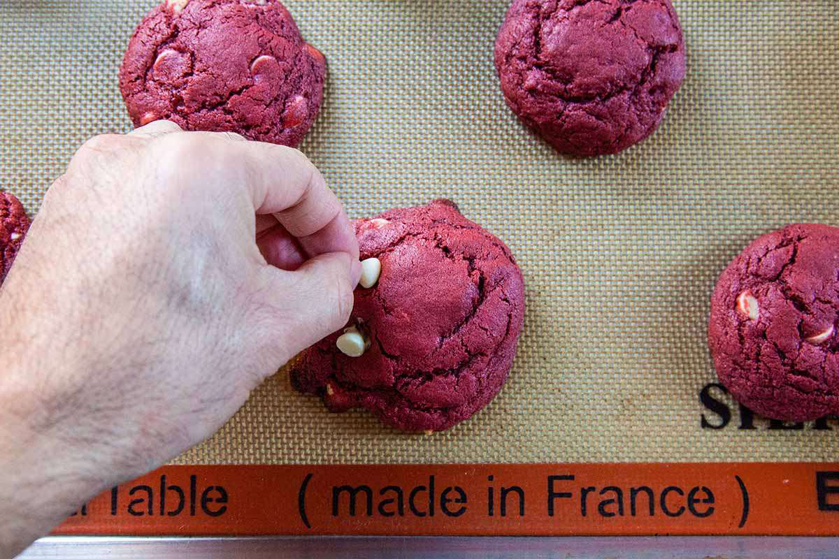 Red Velvet Cheesecake Cookies top the cookies with more chips