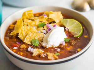 A bowl of crockpot Taco Soup topped with sour cream and chips