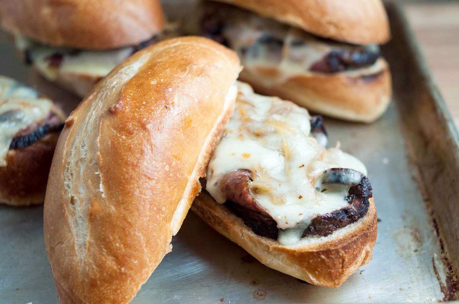 French dip sandwiches on a baking sheet