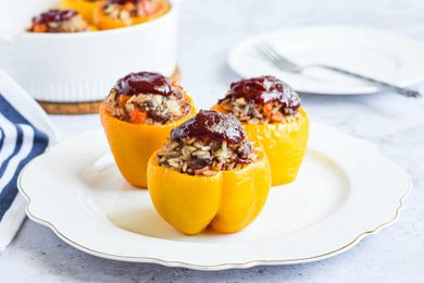 Side view of three bell peppers stuffed with beef and rice.