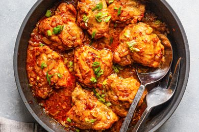 Smothered and covered chicken and gravy in a skillet.