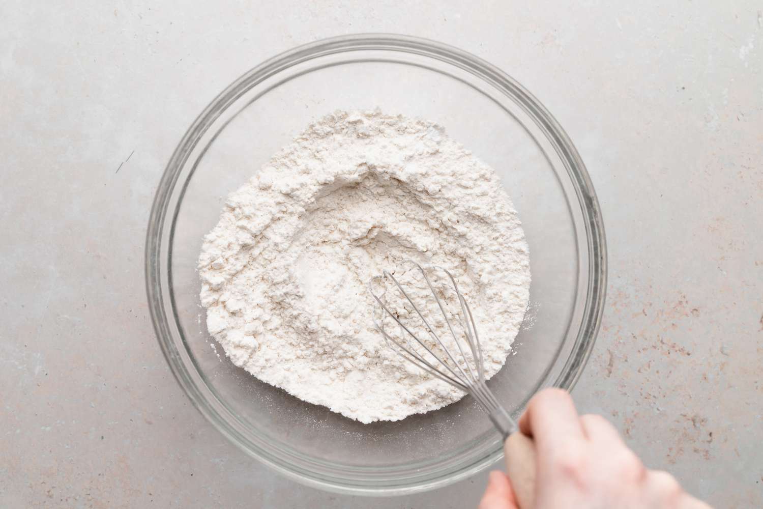 Making biscuits in a glass bowl for a biscuits and gravy recipe.