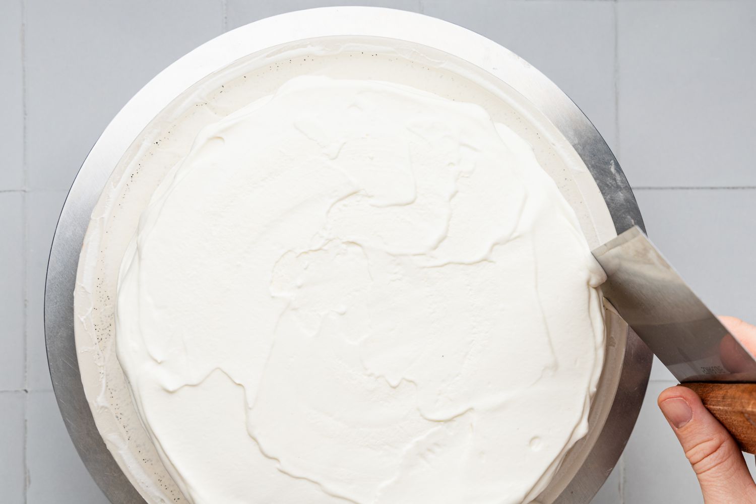 Edges of Whipped Ice Cream Cake Smoothened and Cleaned Using a Bench Scrape
