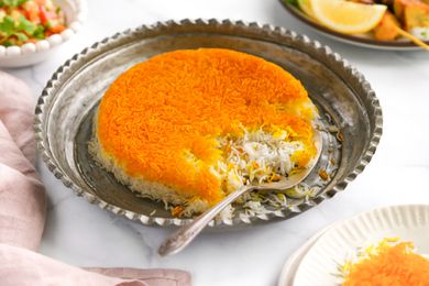 Serving Resting on the Side of Tahdig on an Ornate Silver Platter after Serving It