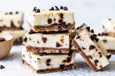 Chocolate chip cheesecake bars stacked up in a small pile
