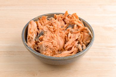 Canned salmon in a bowl on a wooden counter