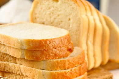 Closeup view of white bread slices on a wooden cutting board