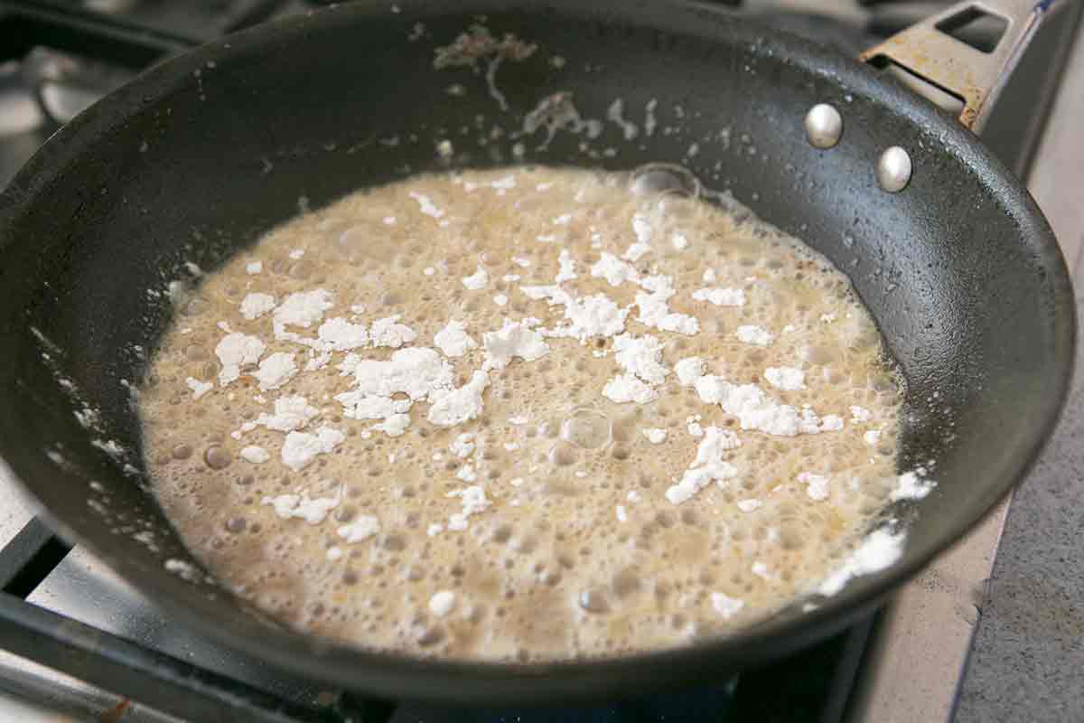 Flour sprinkled in oil for Making Gravy For Country Fried Sirloin