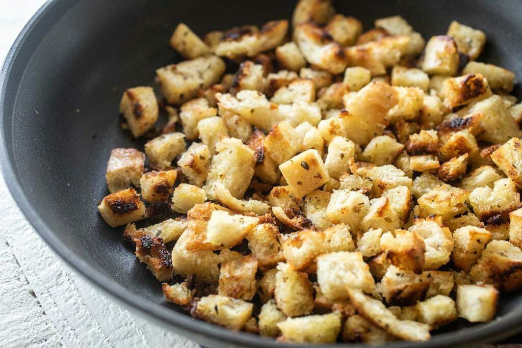 Toast bread cubes in a skillet to make croutons for easy potato soup