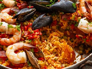 Seafood paella with rice, shrimp, mussels, and vegetables in a pan