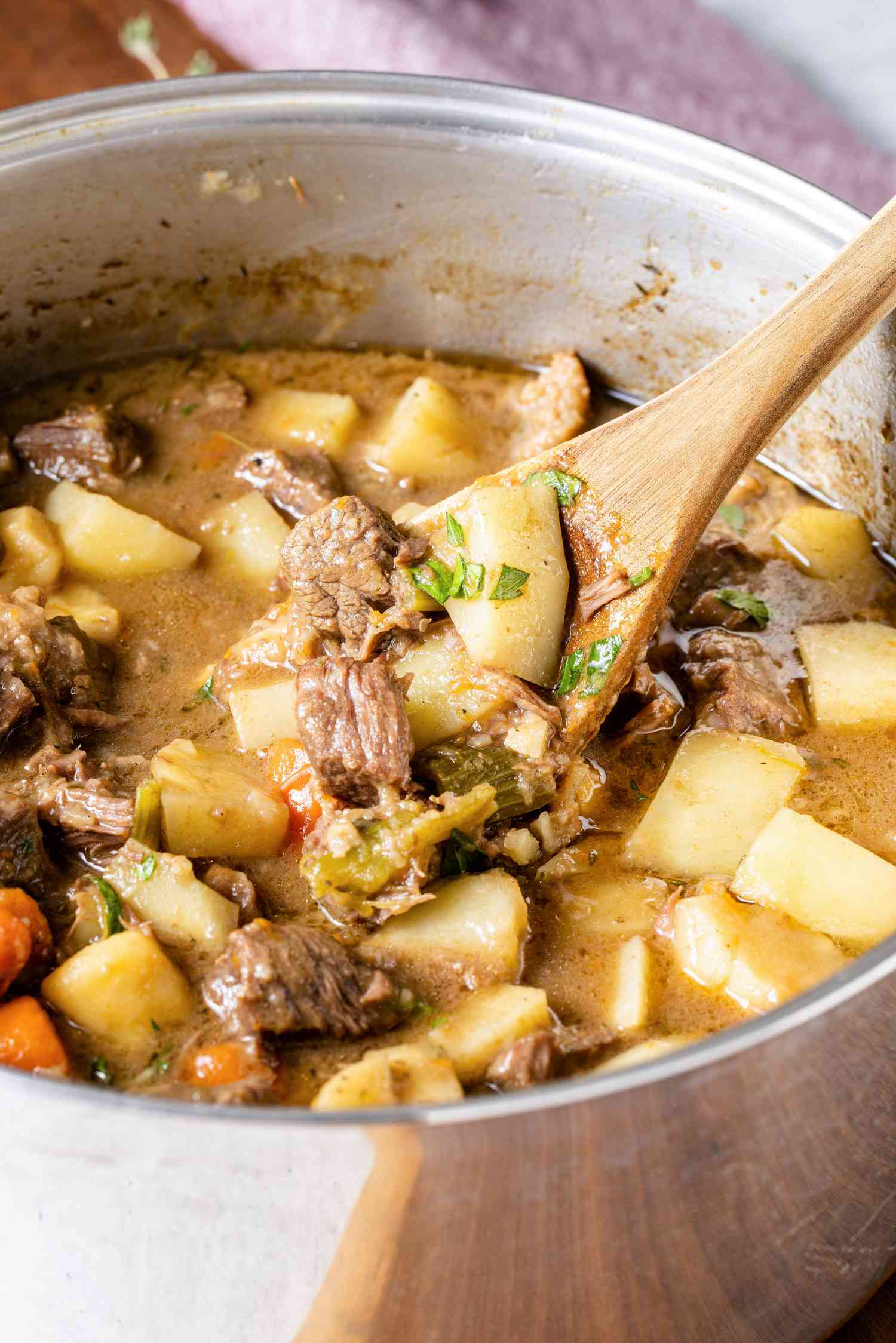 Pot of Easy Beef Stew with Some Lifted on a Wooden Spoon
