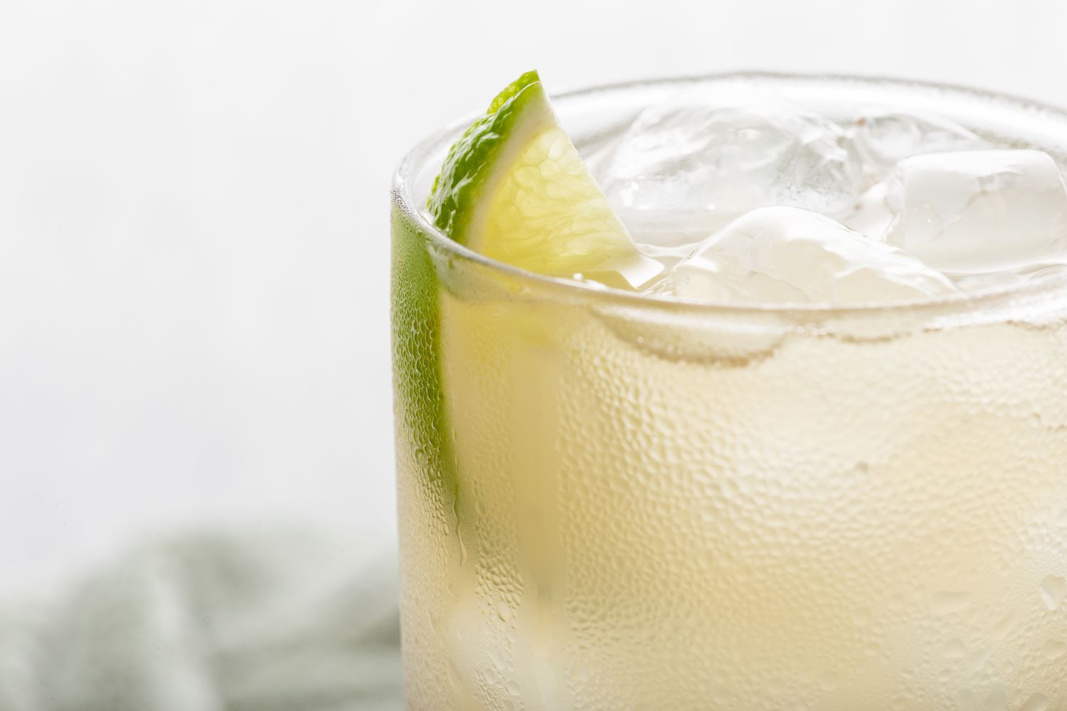 Close up of a ginger drink with a lime garnish.
