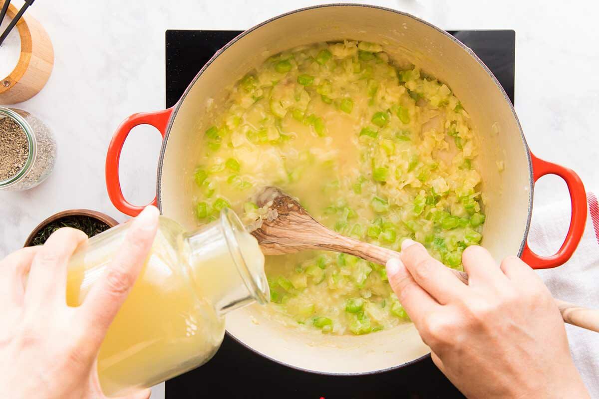 Broth is added to the filling in a dutch oven to make a favorite Chicken Pot PIe.