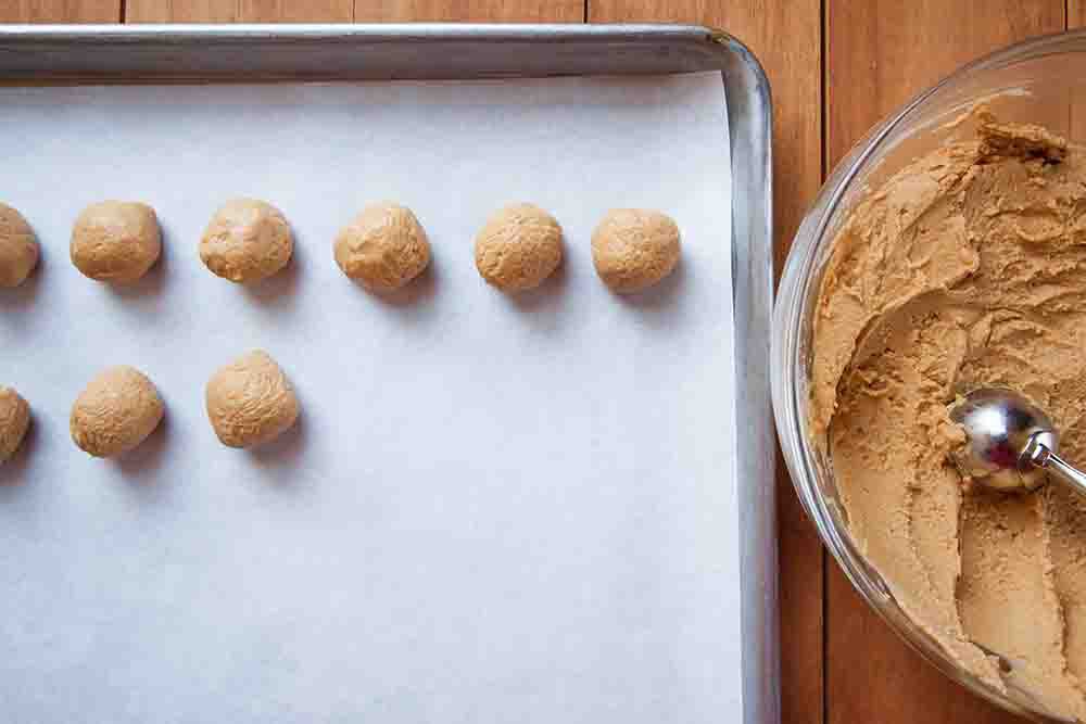 Filling for Peanut butter palls set rolled into balls and set on a baking tray covered in parchment.