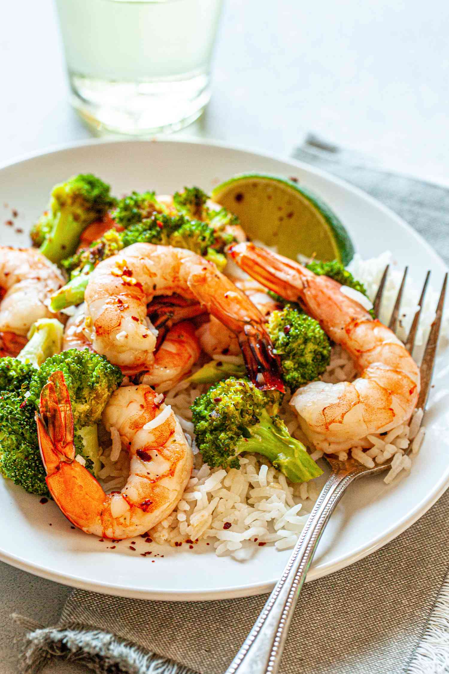 Spicy Honey Roasted Shrimp and Broccoli on a white plate with a fork.