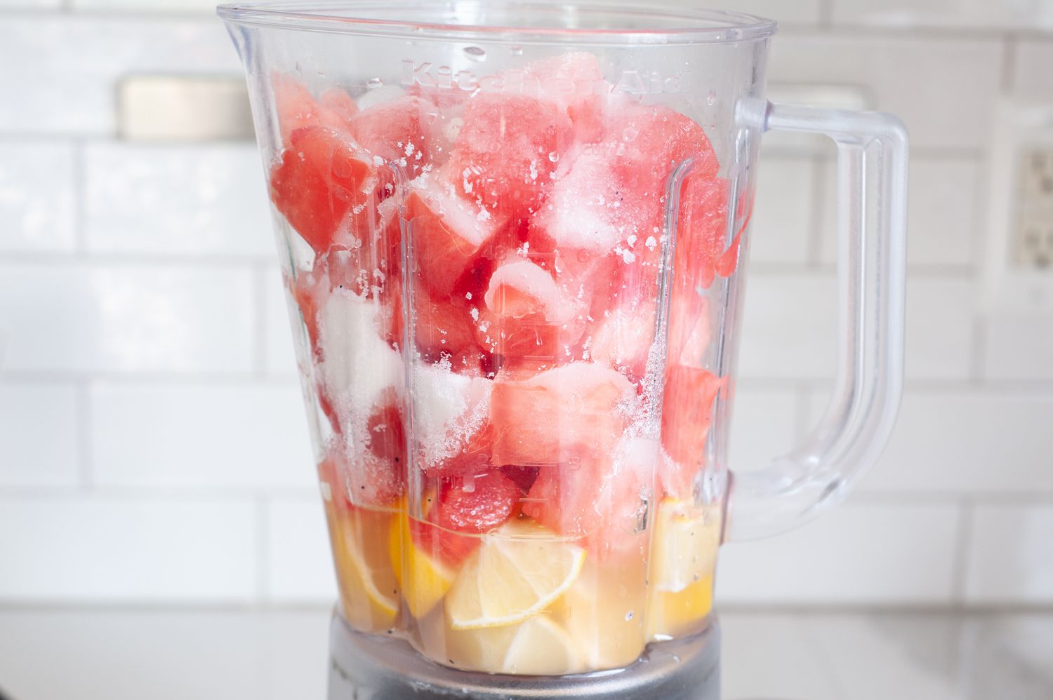 Blender with cubed watermelon and lemons to make blender watermelon lemonade