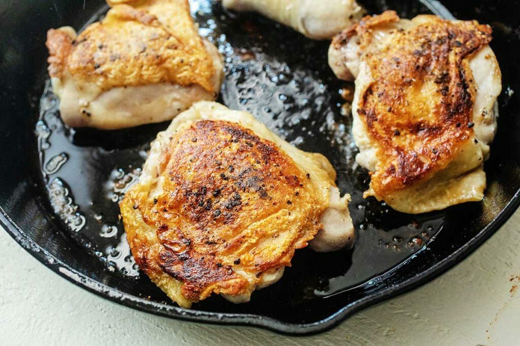 Brown chicken thighs before braising with sweet potatoes