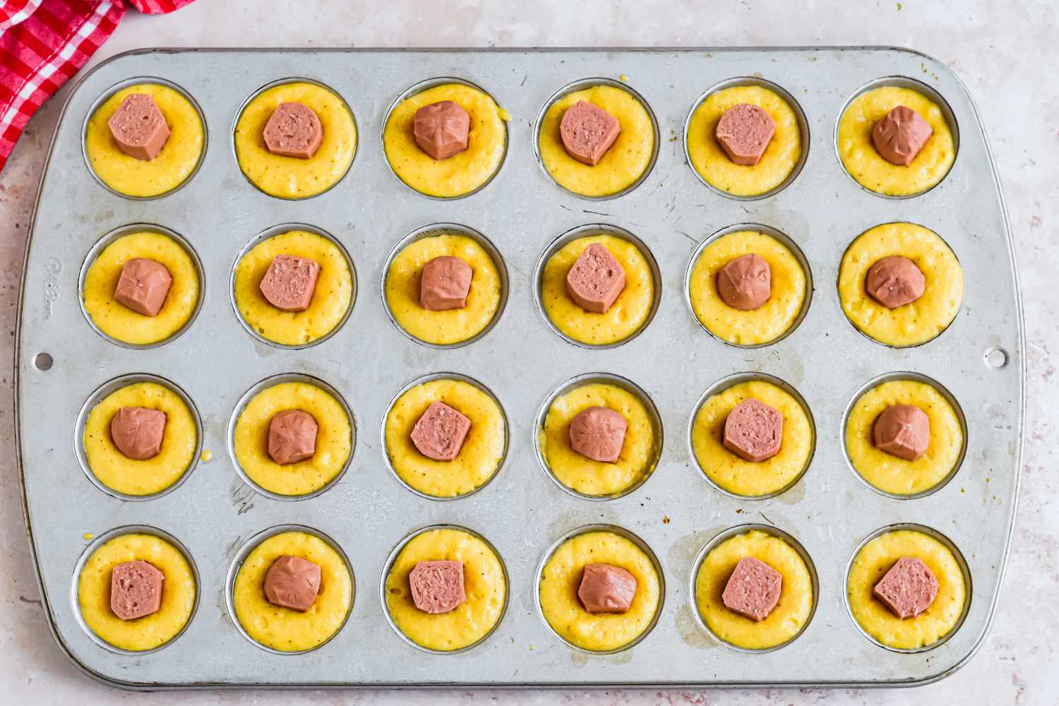 Hot Dog Pieces Pushed Into Each Filled Muffin Hole 