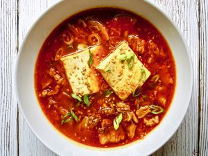 Overhead view of a bowl of spicy kimchi and pork belly stew.