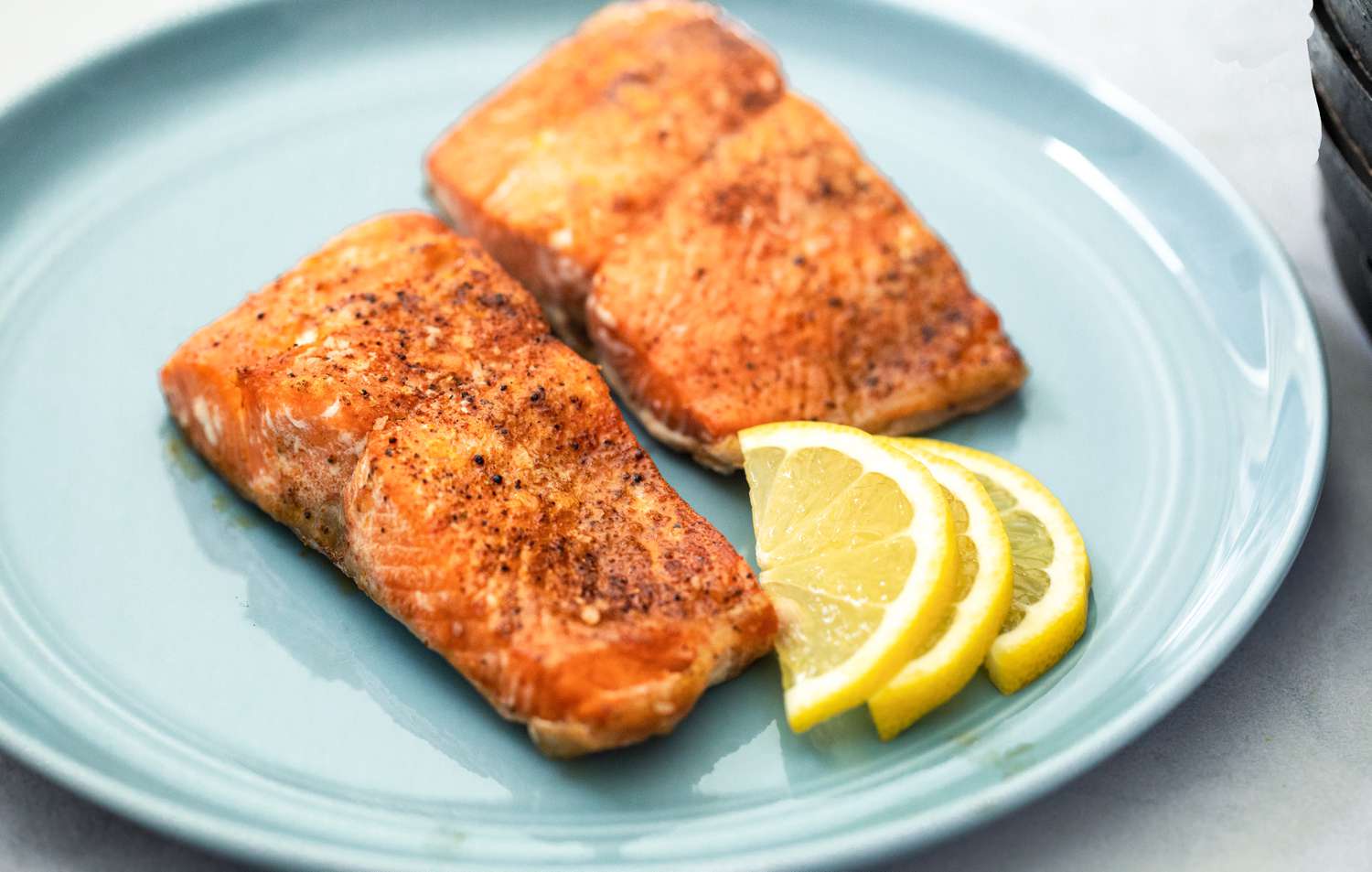 Air Fryer Salmon on a Plate with Lemon Wedges