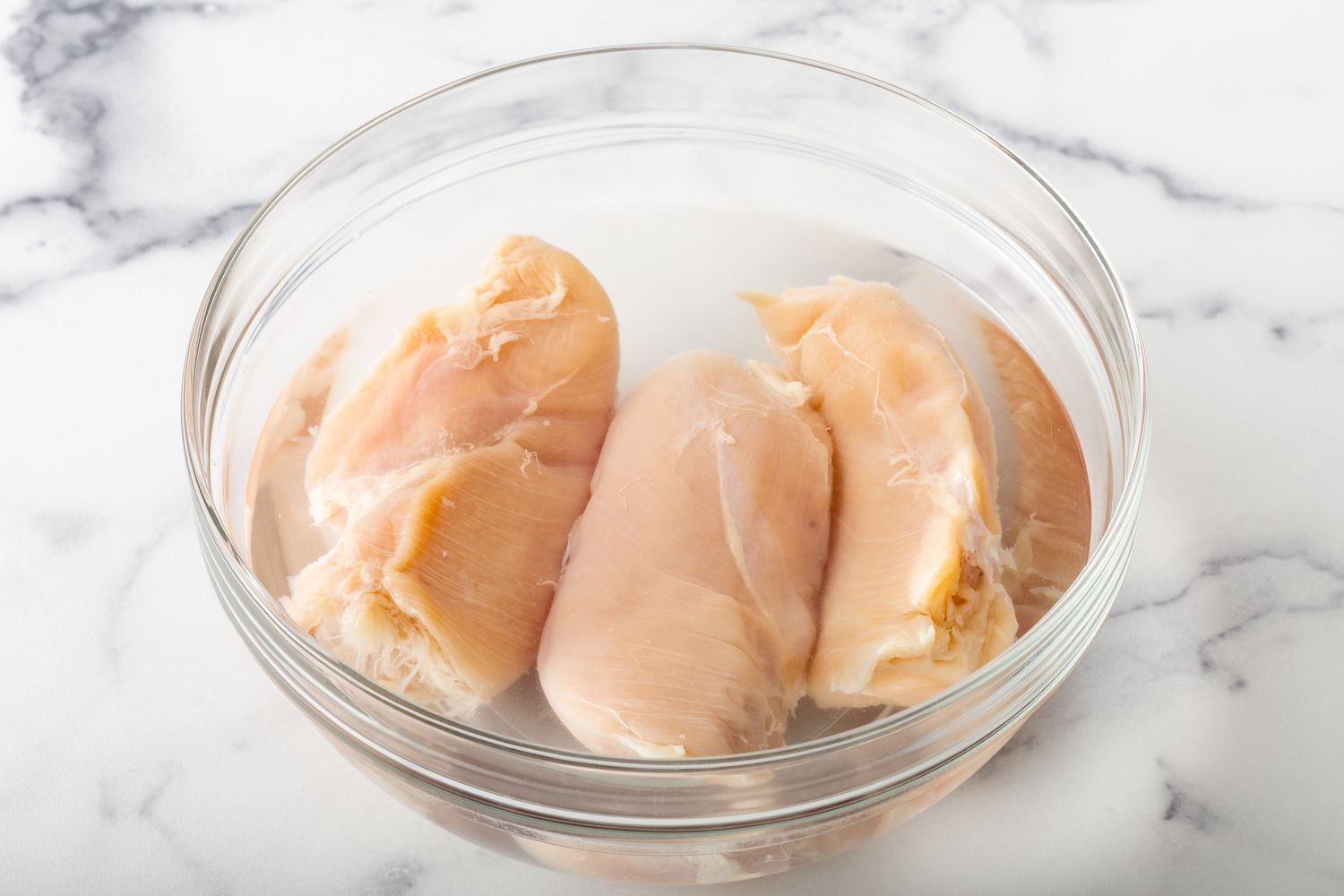 Chicken breasts in a glass bowl to show how to cook chicken breast.