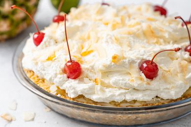 Piña Colada Pie Topped with Toasted Coconut Flakes and Maraschino Cherries