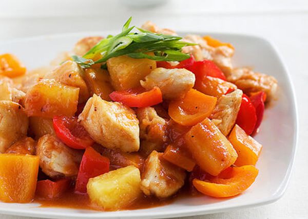 A white plate piled high with sweet and sour chicken