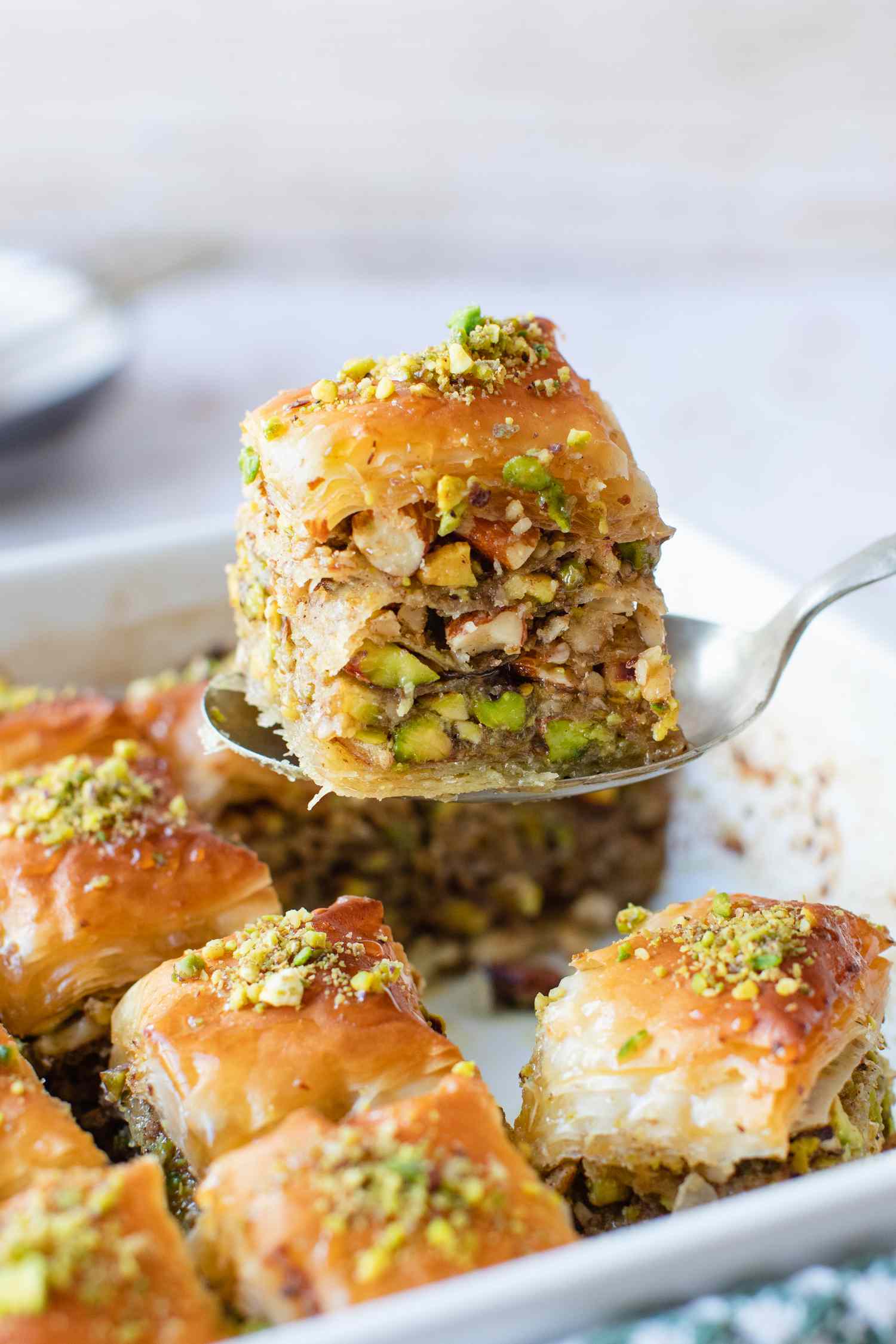 Slice of Baklava Raised from Casserole Dish (with More Baklava) Using a Spoon 