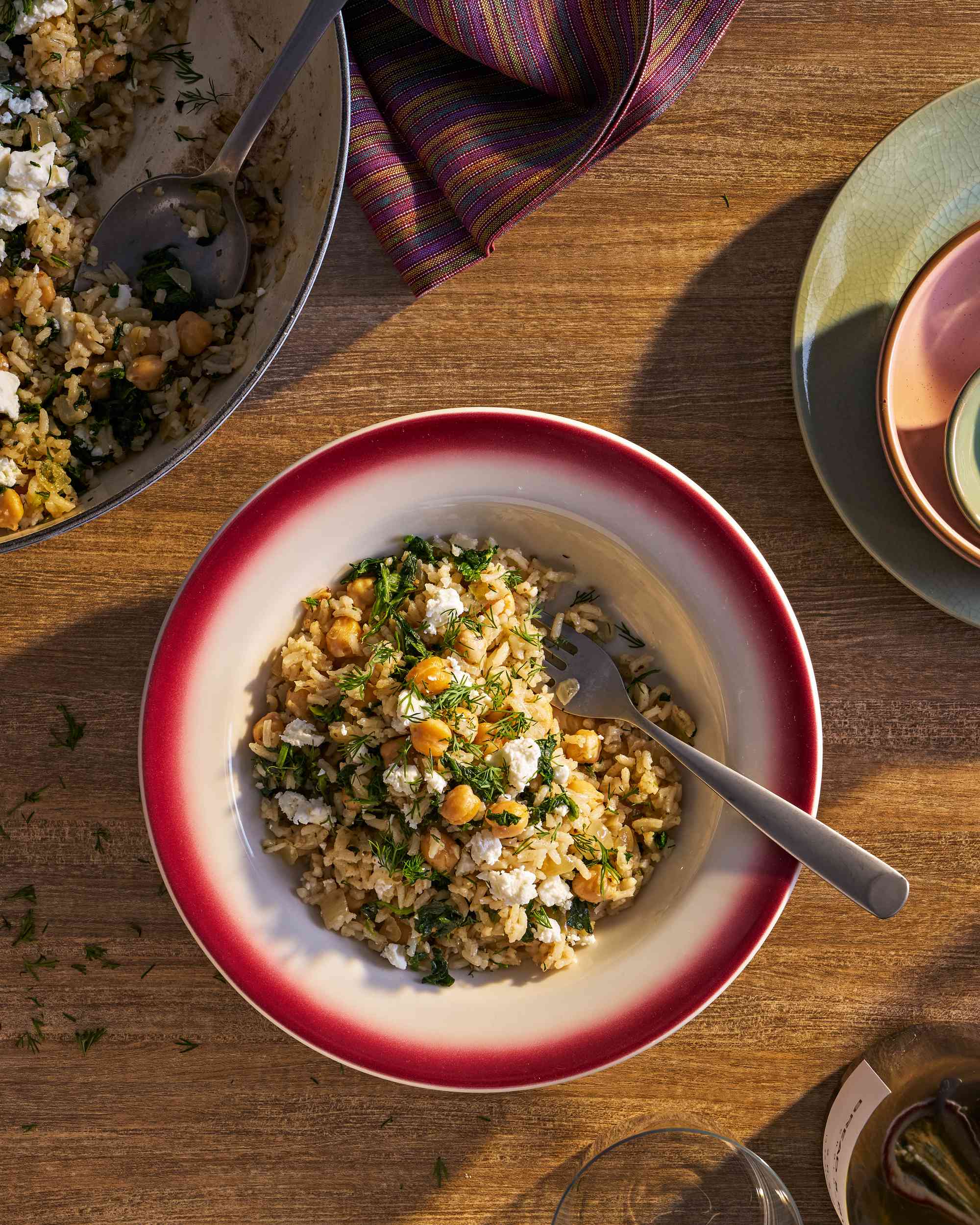 Bowl of chickpea spinach rice alongside a skillet