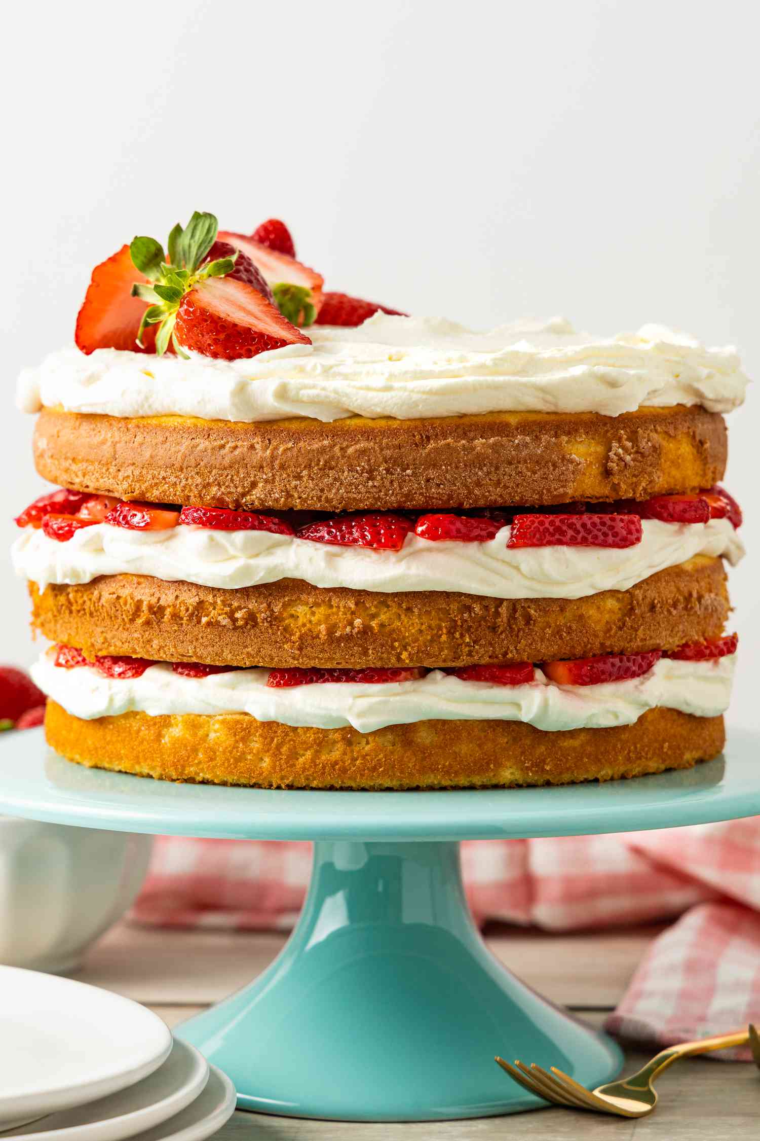 Strawberry Shortcake Cake Garnished With Halved Strawberries on a Cake Stand