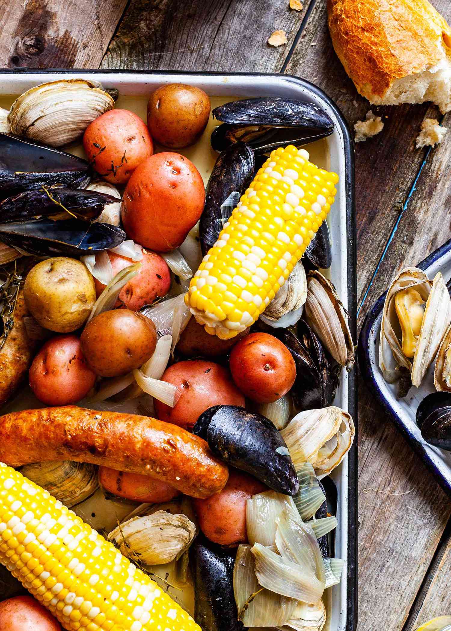 Clams, potatoes, sausage, and corn on the cob on a tray