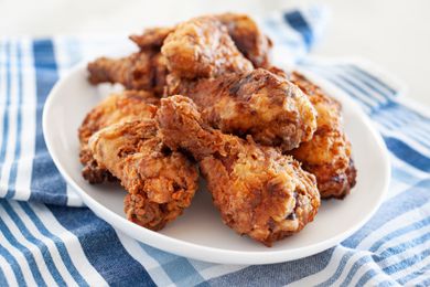 Side view of fried chicken breast stacked on a platter.