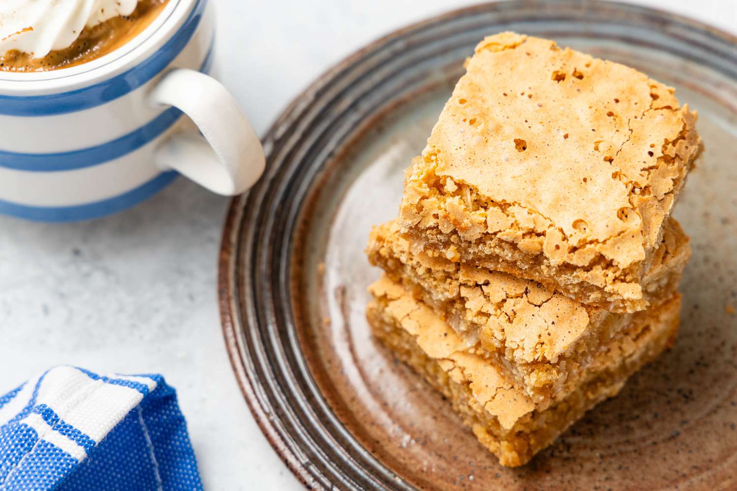 Overhead: Stack of Sad Cake Slices on a Small Plate and a Cup of Coffee and a Table Napkin