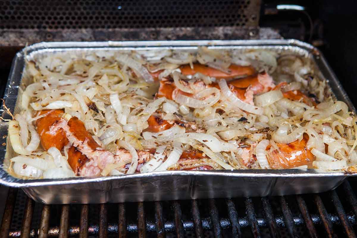 Polish sausage on the grill with sauerkraut and onion