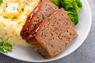Two slices of meatloaf on a plate with mashed potatoes