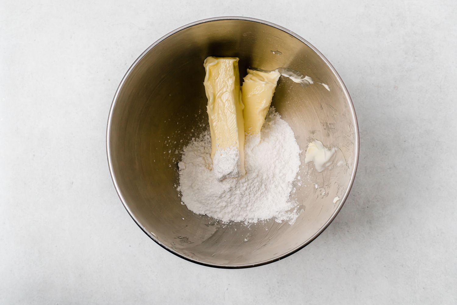 Butter and sugar in a metal bowl of a stand mixer to make shortbread cookies.