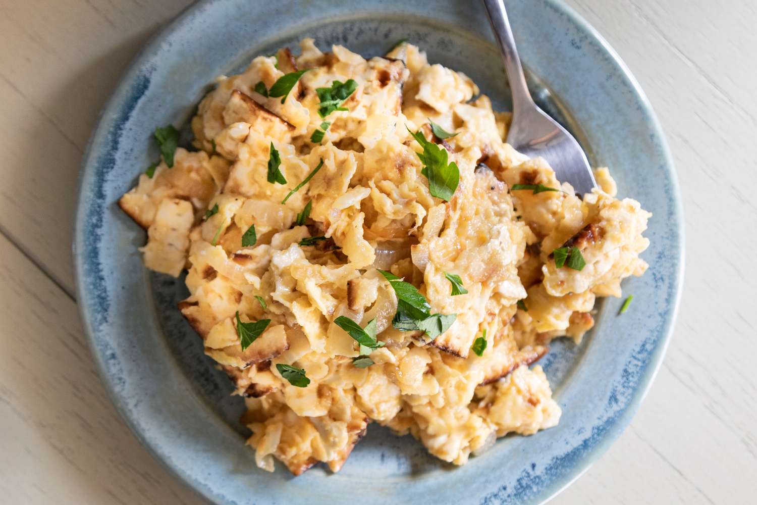 Matzo brei on a plate with a fork.