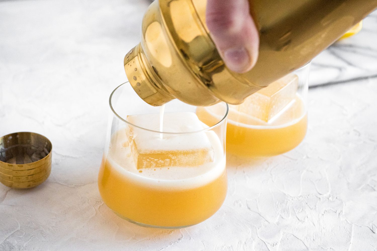 Pour Amaretto Sour into Glasses from Cocktail Shaker 
