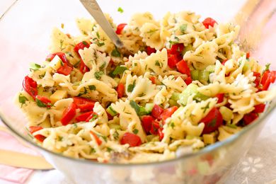 Bowl of pasta salad with mixed vegetables and herbs
