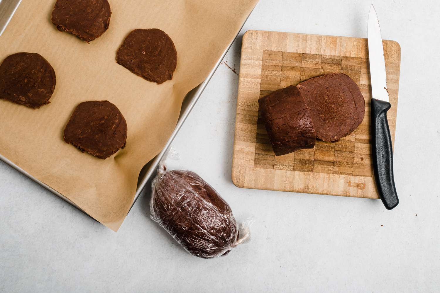 Slicing dough for chocolate shortbread into rounds and putting on baking sheet.