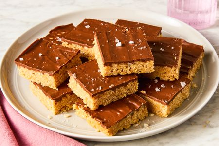 Angled view of sliced squares of Scotcheroos stacked on a plate