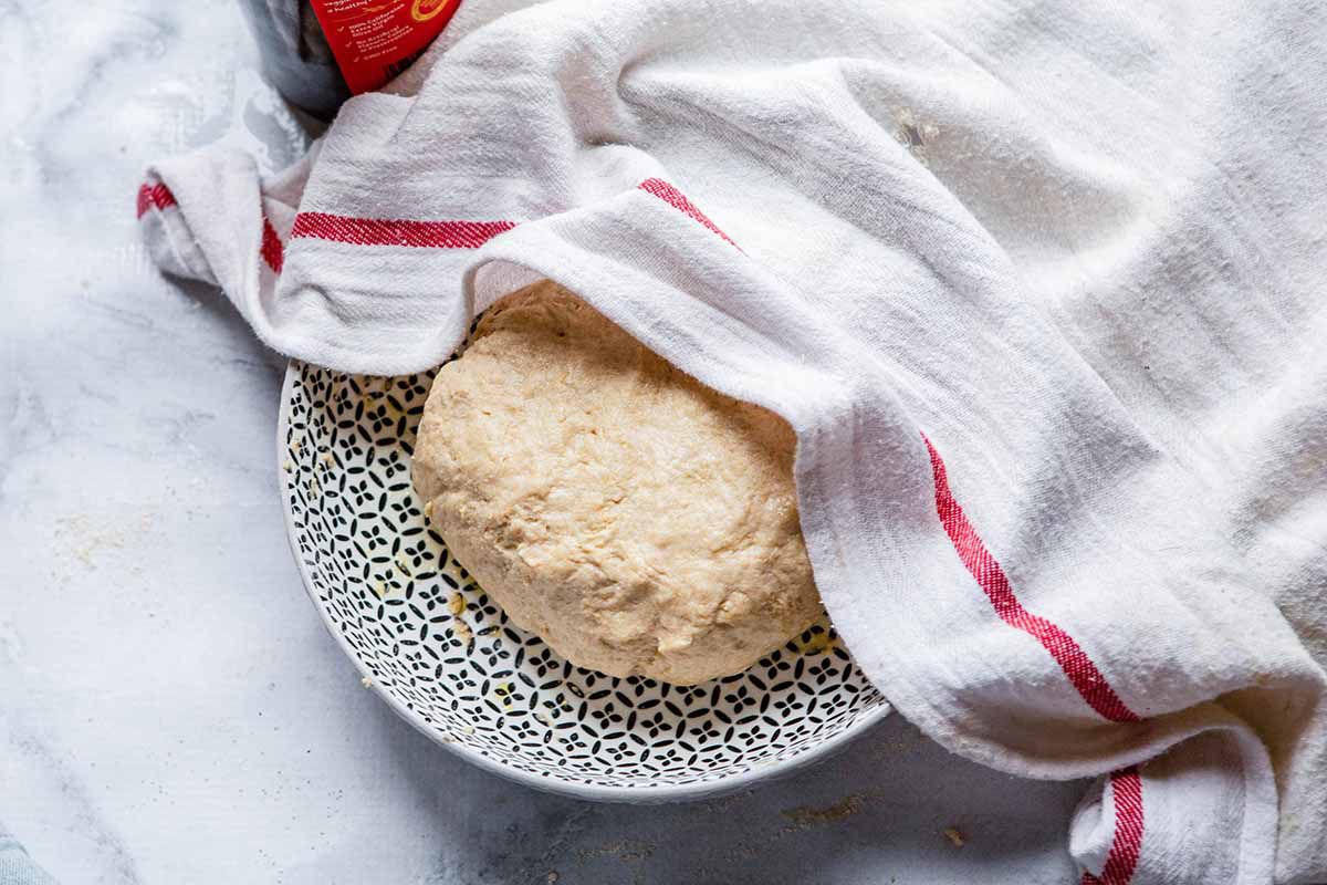 Homemade Naan Recipe - dough on plate covered with dish towel