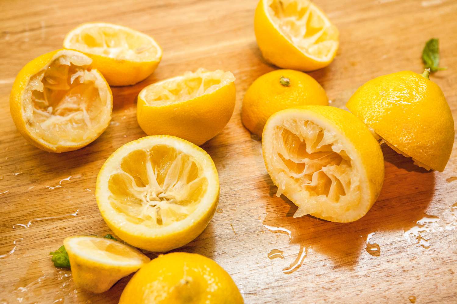 Spent lemon halves on a wooden cutting board